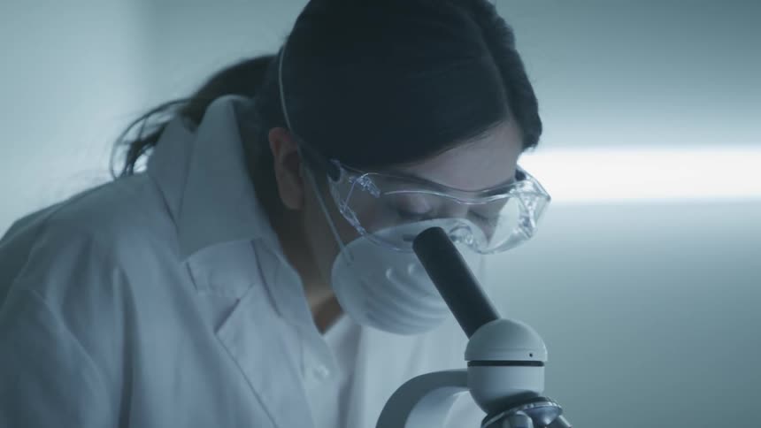 A woman looking in a microscope