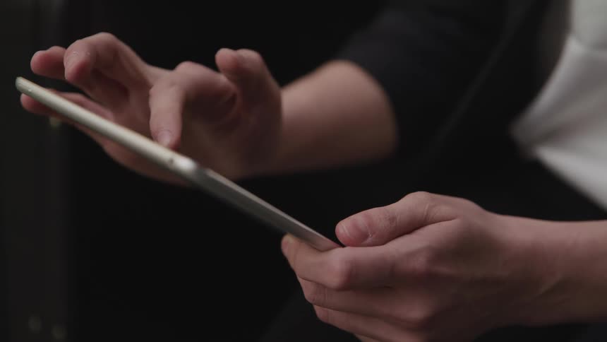 Man with a long sleeve t shirt uses a tablet