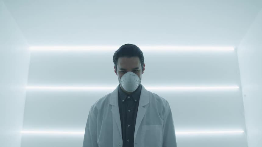 A doctor standing in a bright room with a mask on