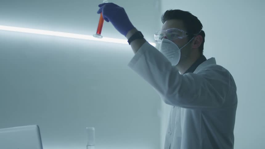 A male caucasian examining a test tube