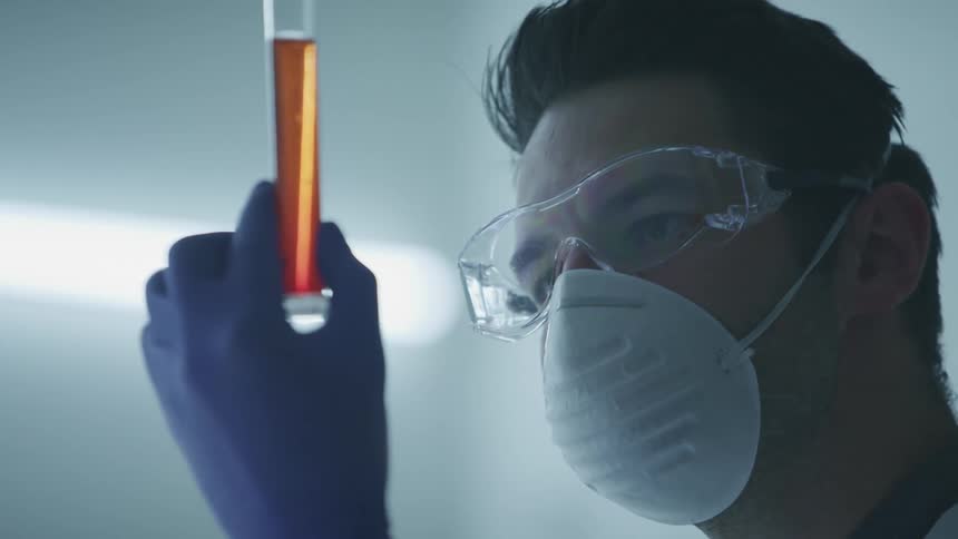 A man examines a liquid in a test tube