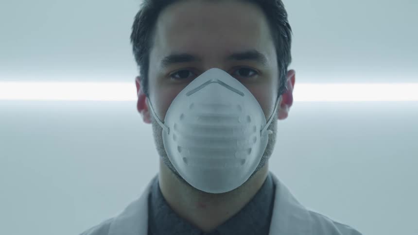A caucasian male standing with a face mask on
