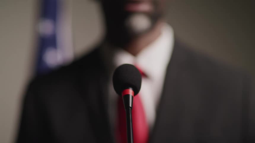 A politician is speaking at the microphone