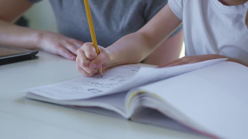A child is writing in a notebook