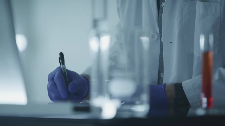 A scientist is writing in the lab