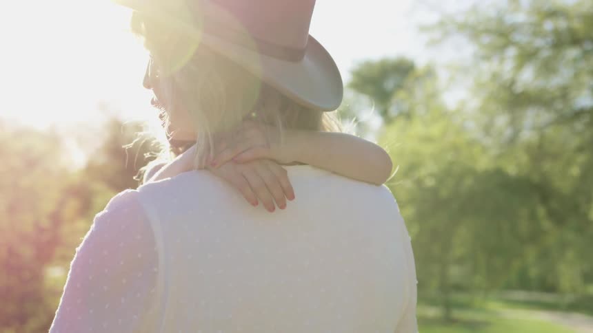 A mother carries her daughter in a public park