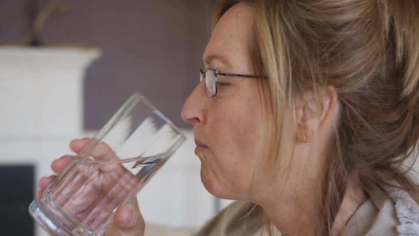 A woman takes a drink of water