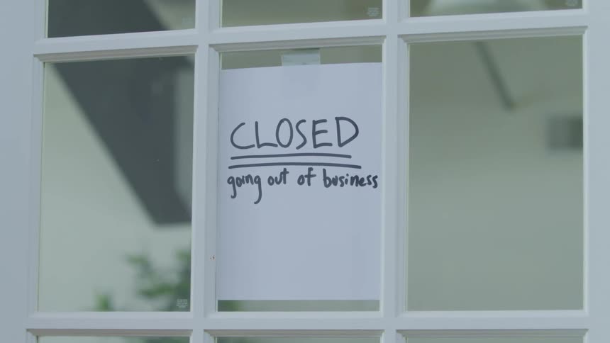 A door of a business closes with a sign on it