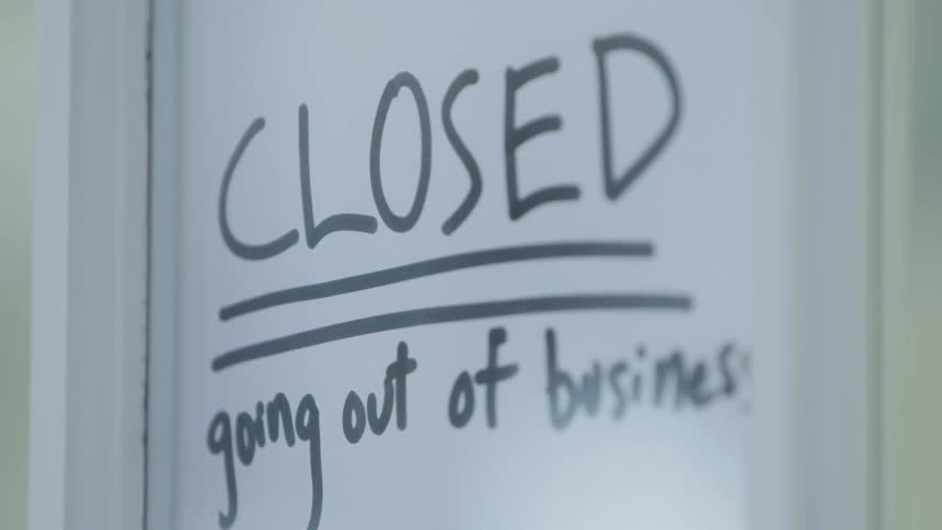 A door on a store closing with a sign on it