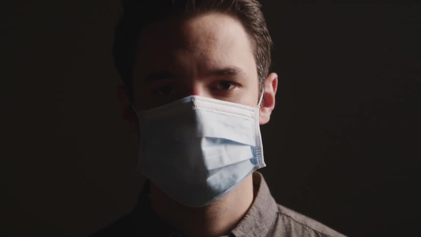 A man with a shirt and a mask looking up and staring