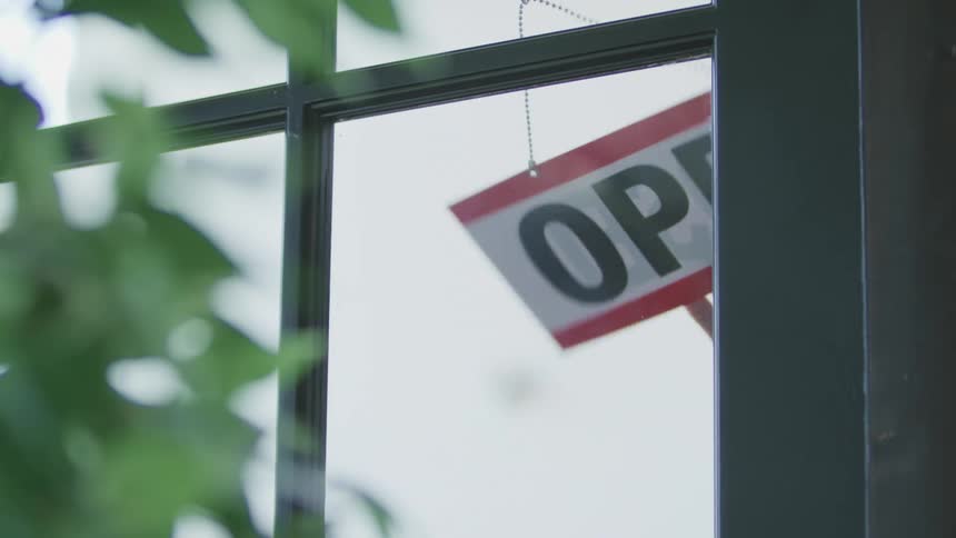 An employee flips a sign on a store window