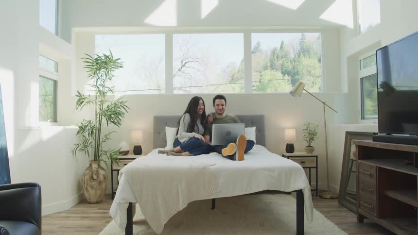 Two people are doing a video conference in bed