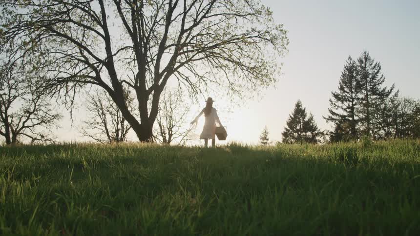 A woman is walking in a grassland area
