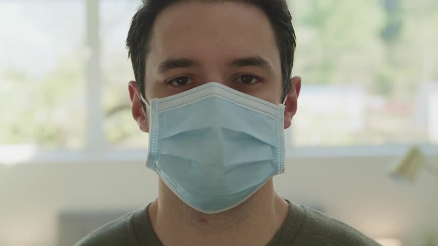 Close up of a mans face wearing a face mask in a room
