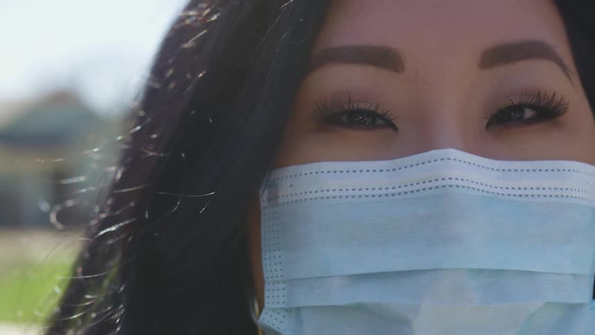A young woman outside with a mask on