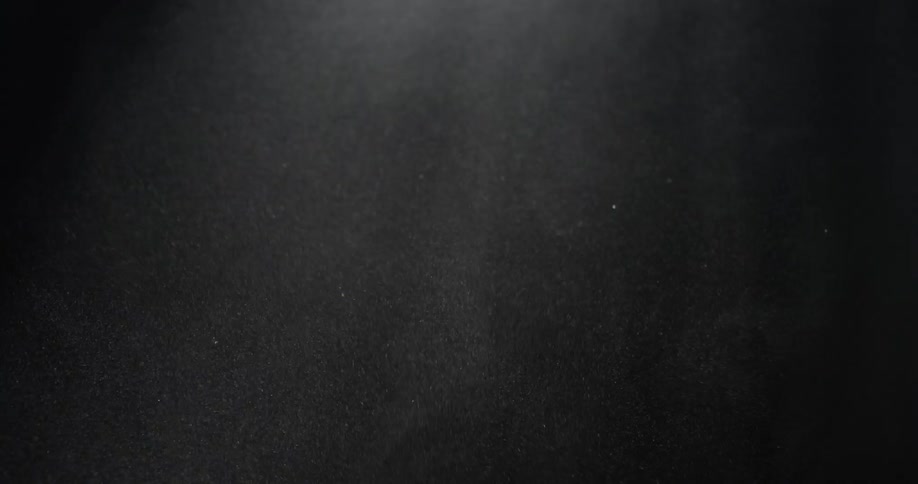 Fine mist of material swirling around in a dark area