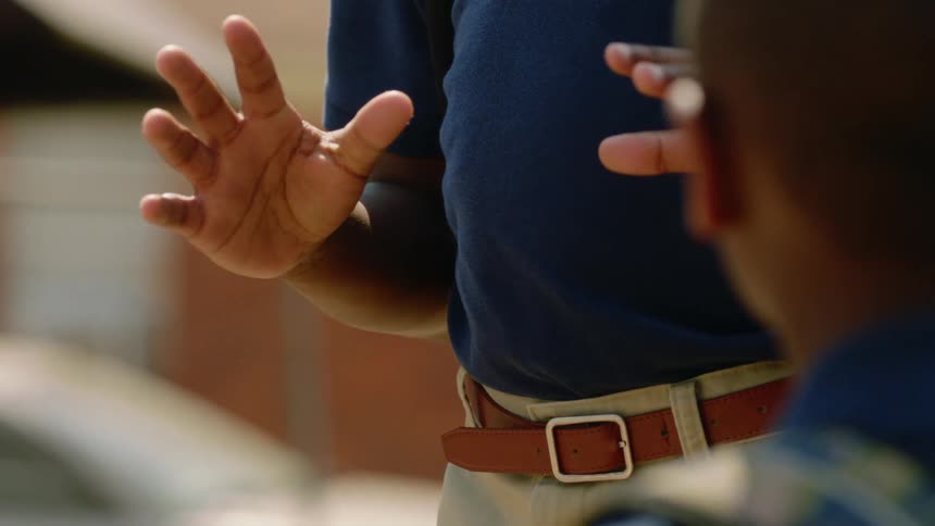 A boy tosses a basketball to another boy