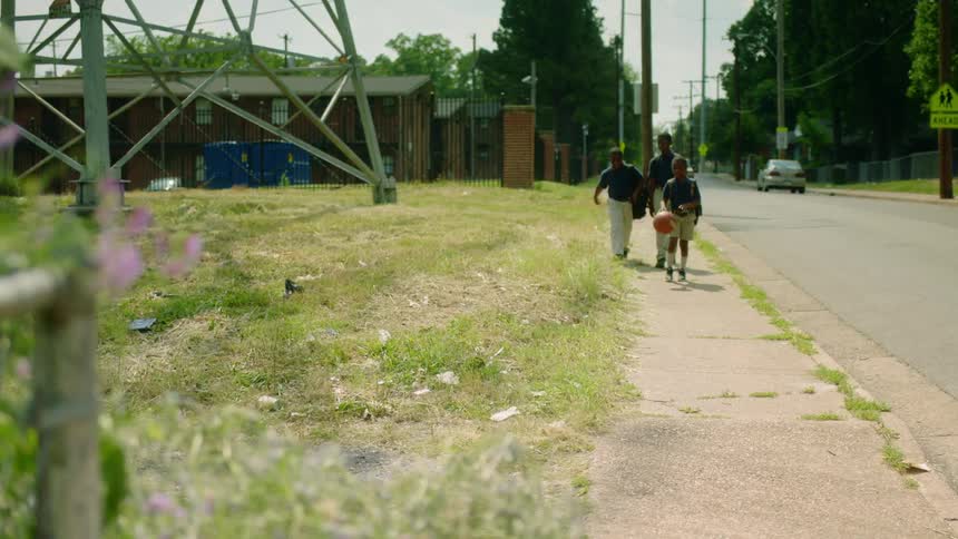 Group of boys walking on the street of a neighborhood while playing with a basketball