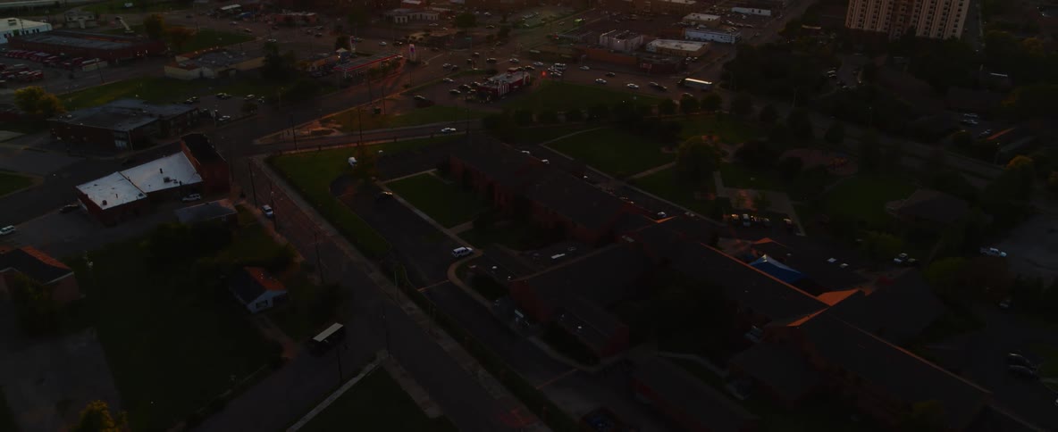 An aerial view of buildings cars and a body of water in a city