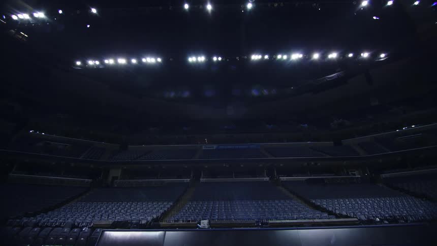 Overhead lights shining down on empty seats in an auditorium
