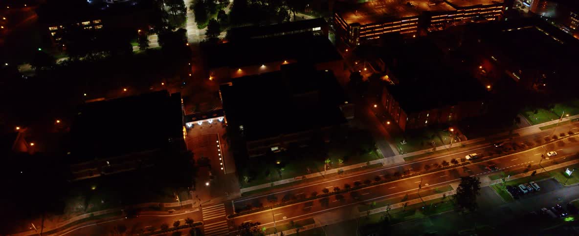 An aerial view of cars driving on a city street at night