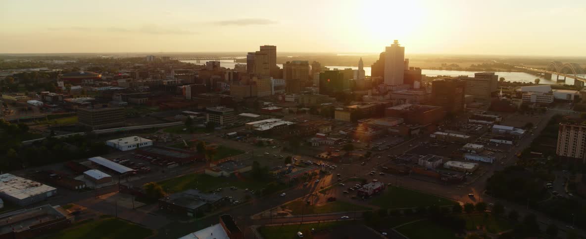 Heavy traffic passes through city streets as the sun sets
