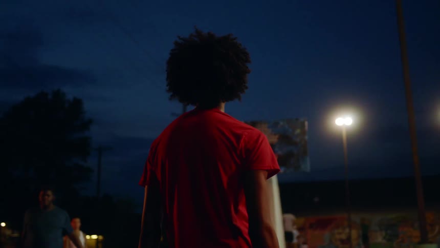 Players stand on the court together at night