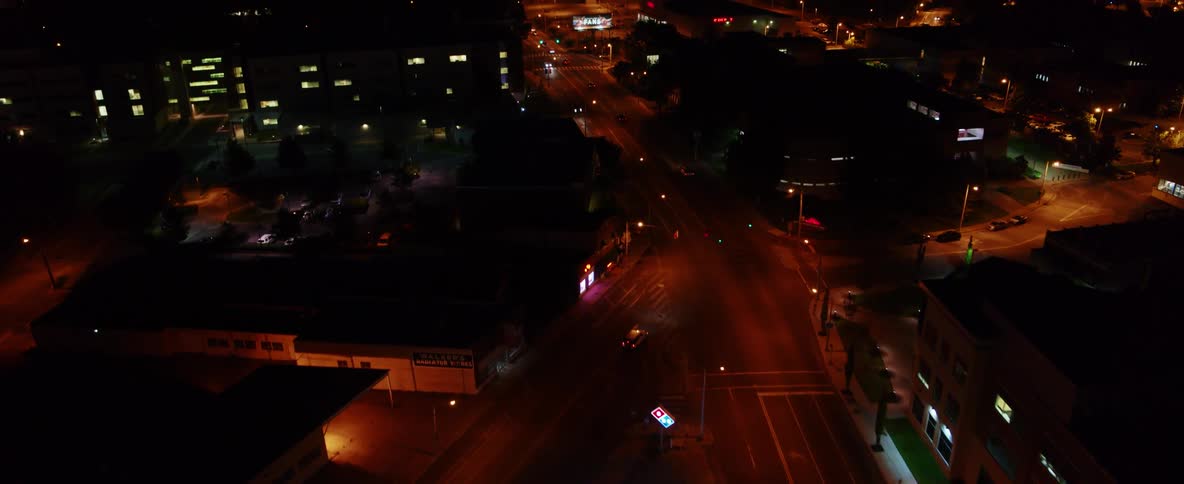An aerial view of buildings and roads with cars driving in a city