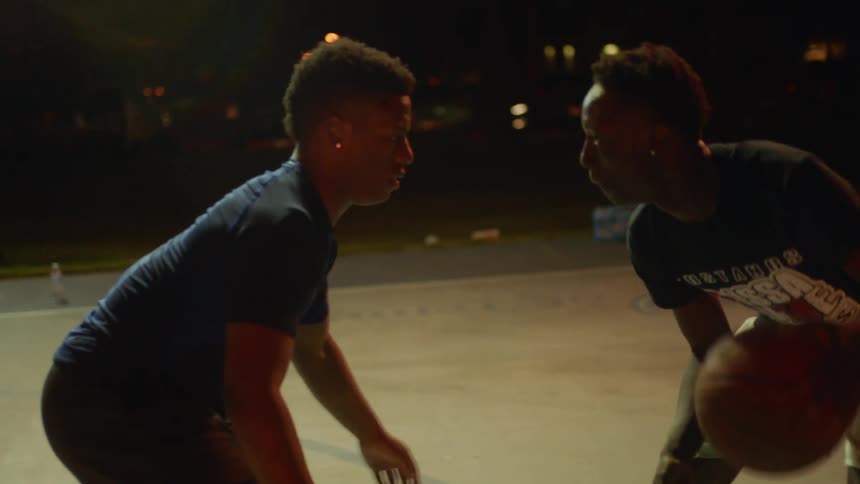Two teenage boys playing basketball together