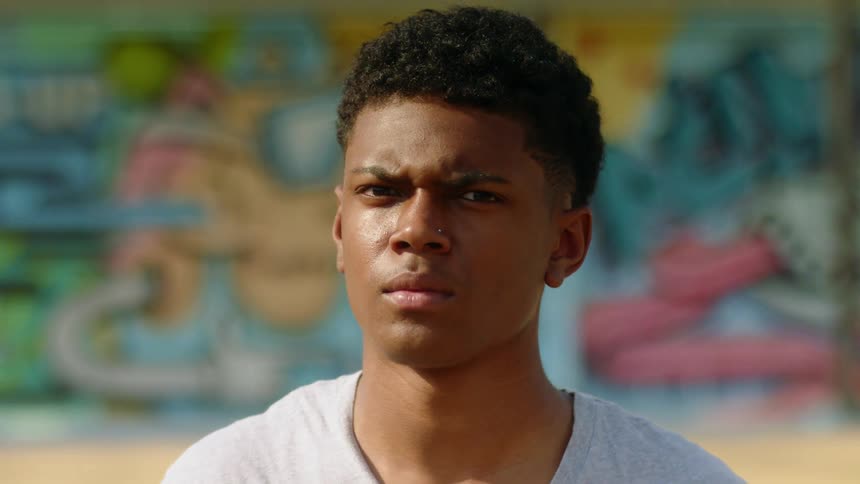 A teenage boy looking off in to the distance outside