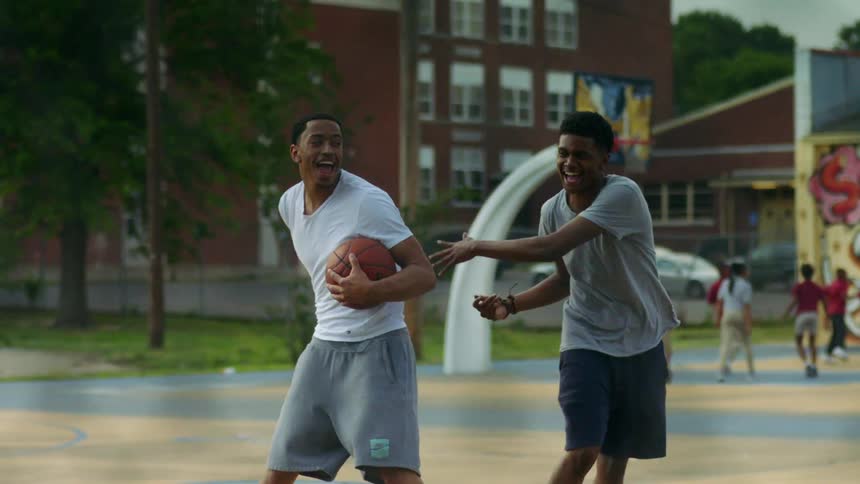 Young people having fun playing basketball in a public court