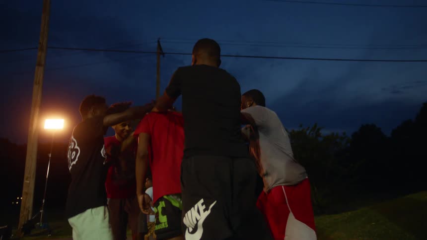 Kids playing basketball gather together cheering