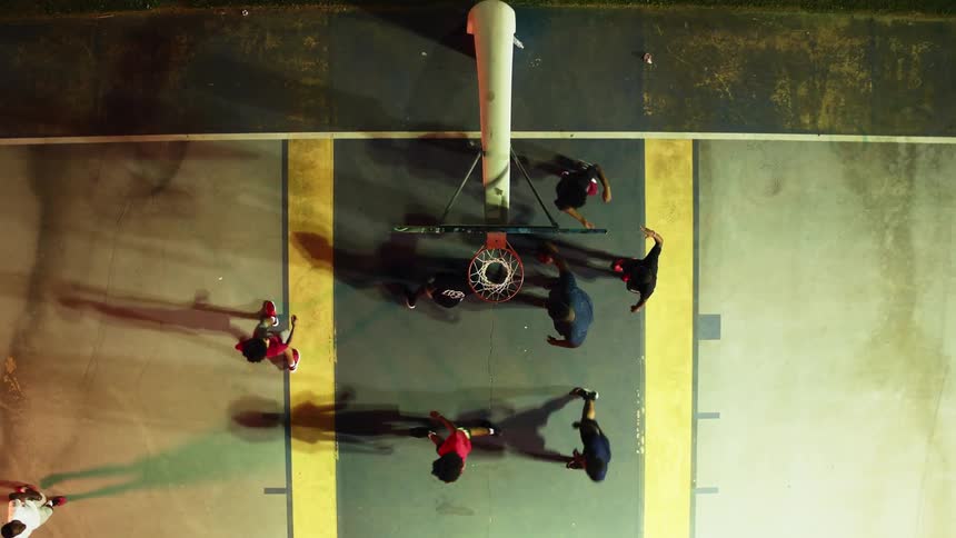 Basketball teammates high five as a player slam dunks the ball into the hoop
