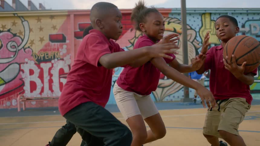 A group of children playing basketball outside