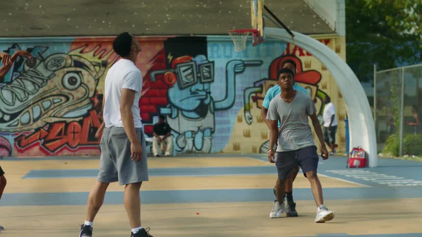 A group of teenage boys playing basketball
