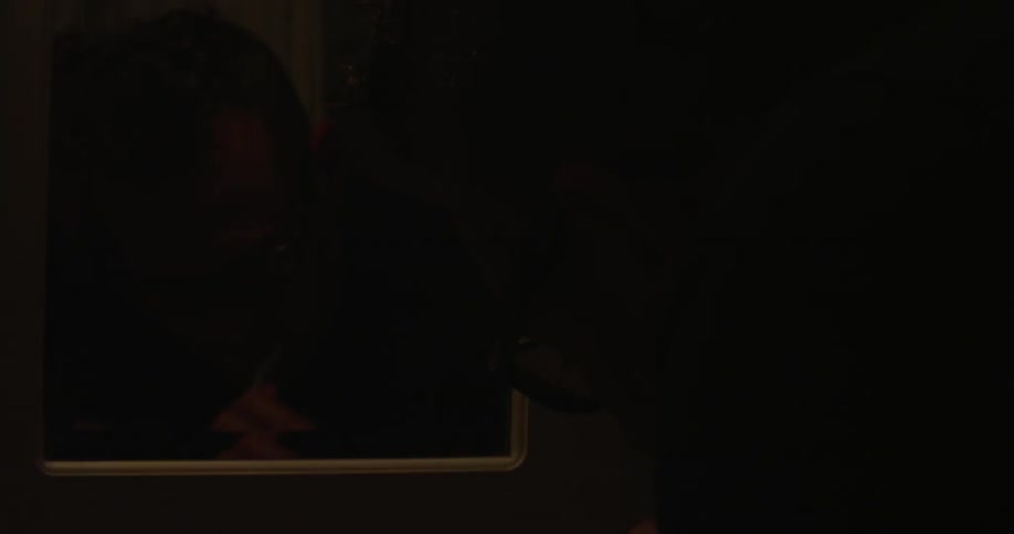 A man brushing his teeth in darkness