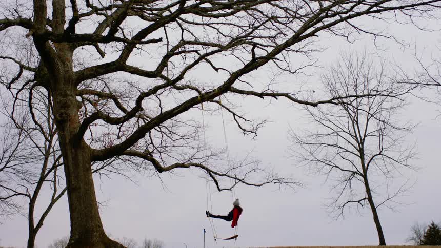 A person is laying in the swing
