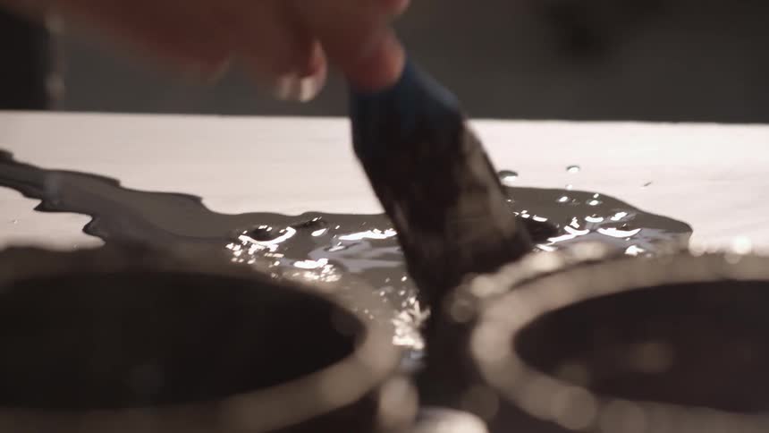 An artist mixes paint on a paint palette