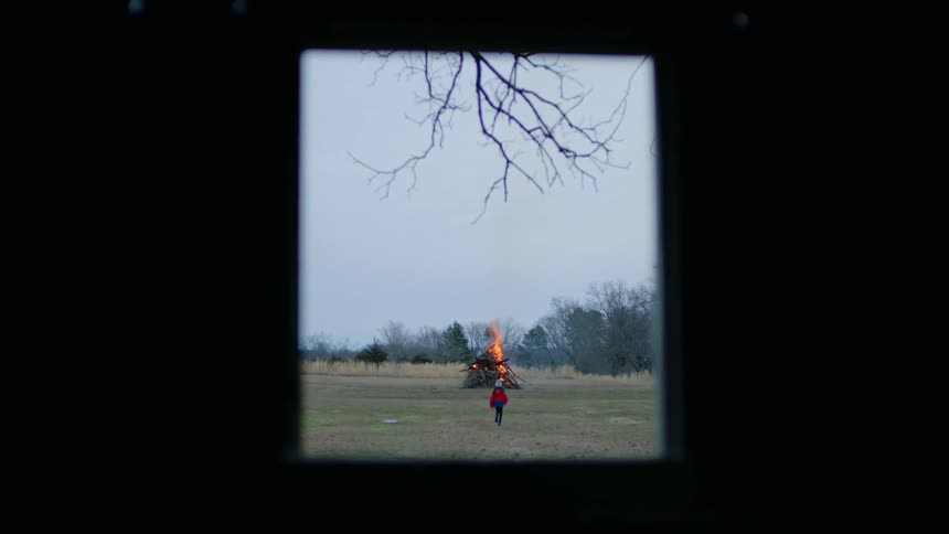 A child runs towards the bonfire