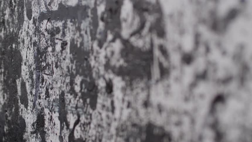 Dark gray paint is smeared against white vertical surface