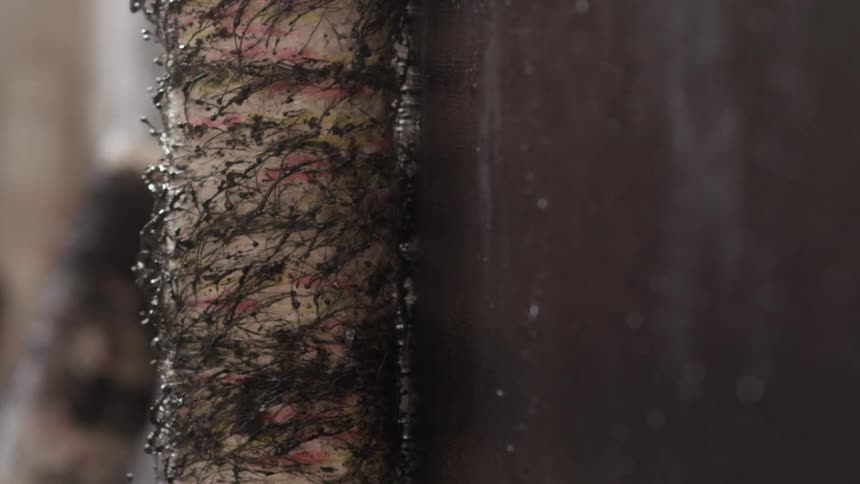 A piece of sugarcane rolling against a wall
