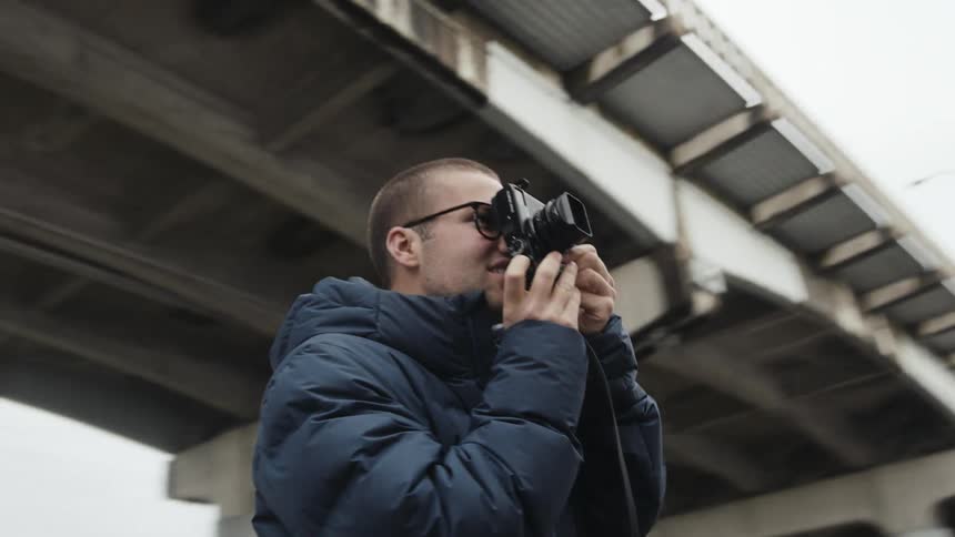 A young man takes pictures outside