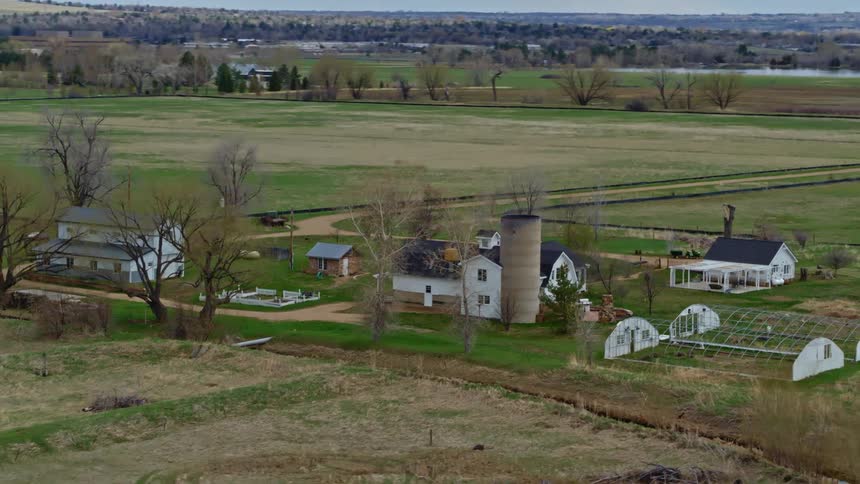 Aerial view of a farm with a river running past it and the grasslands