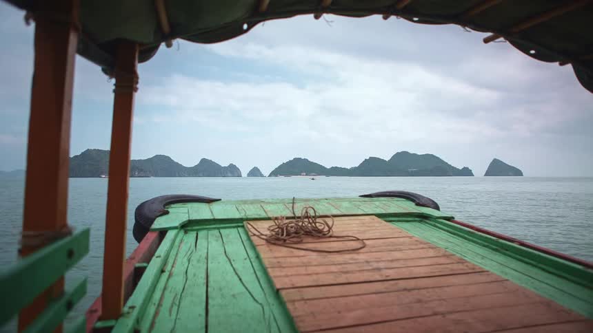 A small boat travels across the ocean towards the coast