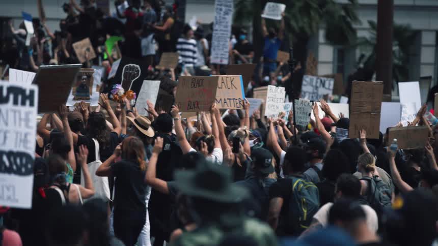 A large group of people holding signs at a protest