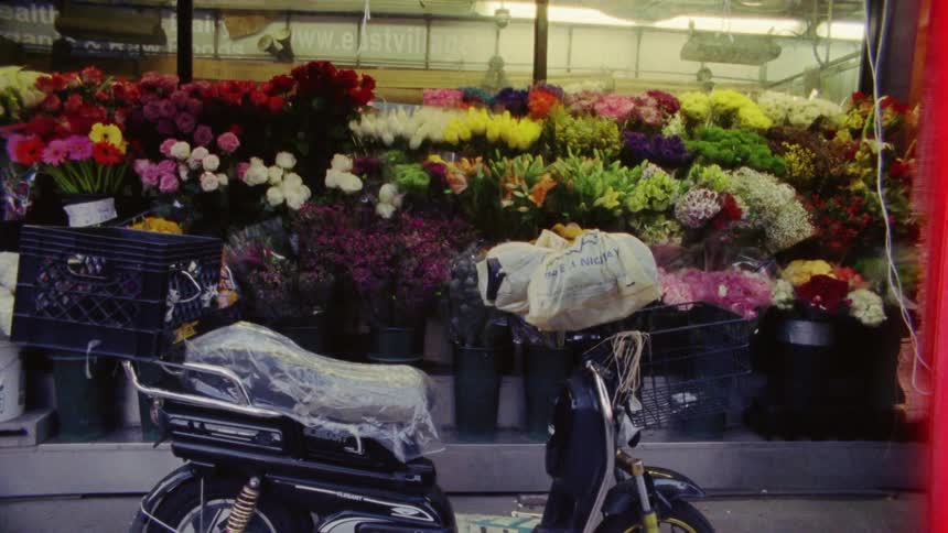 Moped sits parked near flower shop