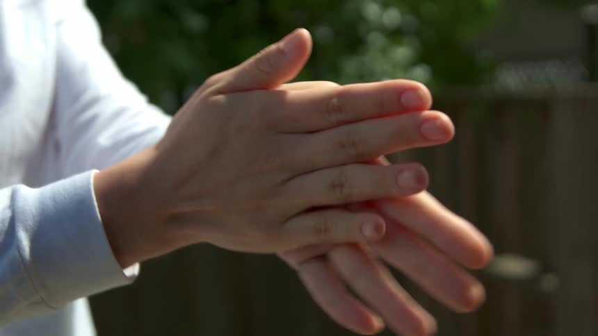 A female puts hand sanitizer on her hands and then rubs them together