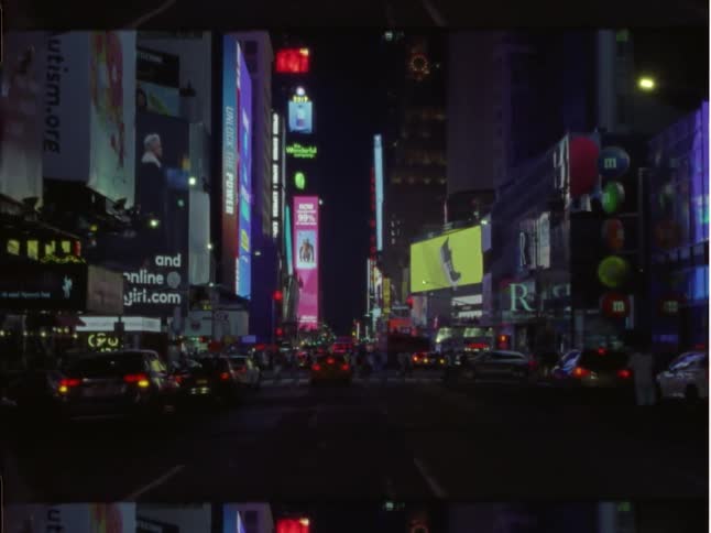 Traffic and pedestrians on a wide street in a metropolis at night