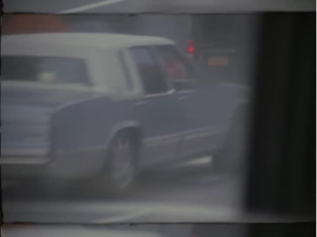 Vehicles pass by a bus in busy city traffic