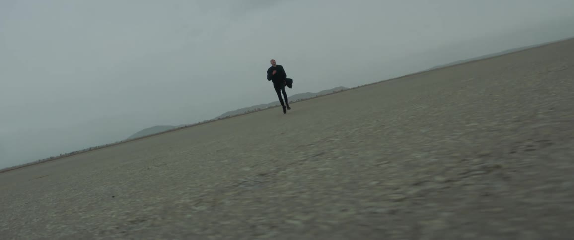 A man runs across a rural dirt field